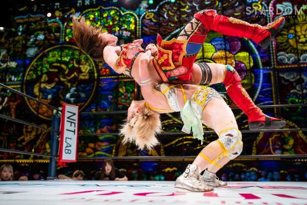 Natsupoi holding Syuri and about to slam her down with a german suplex at KBS Hall (beautiful stained glass background).