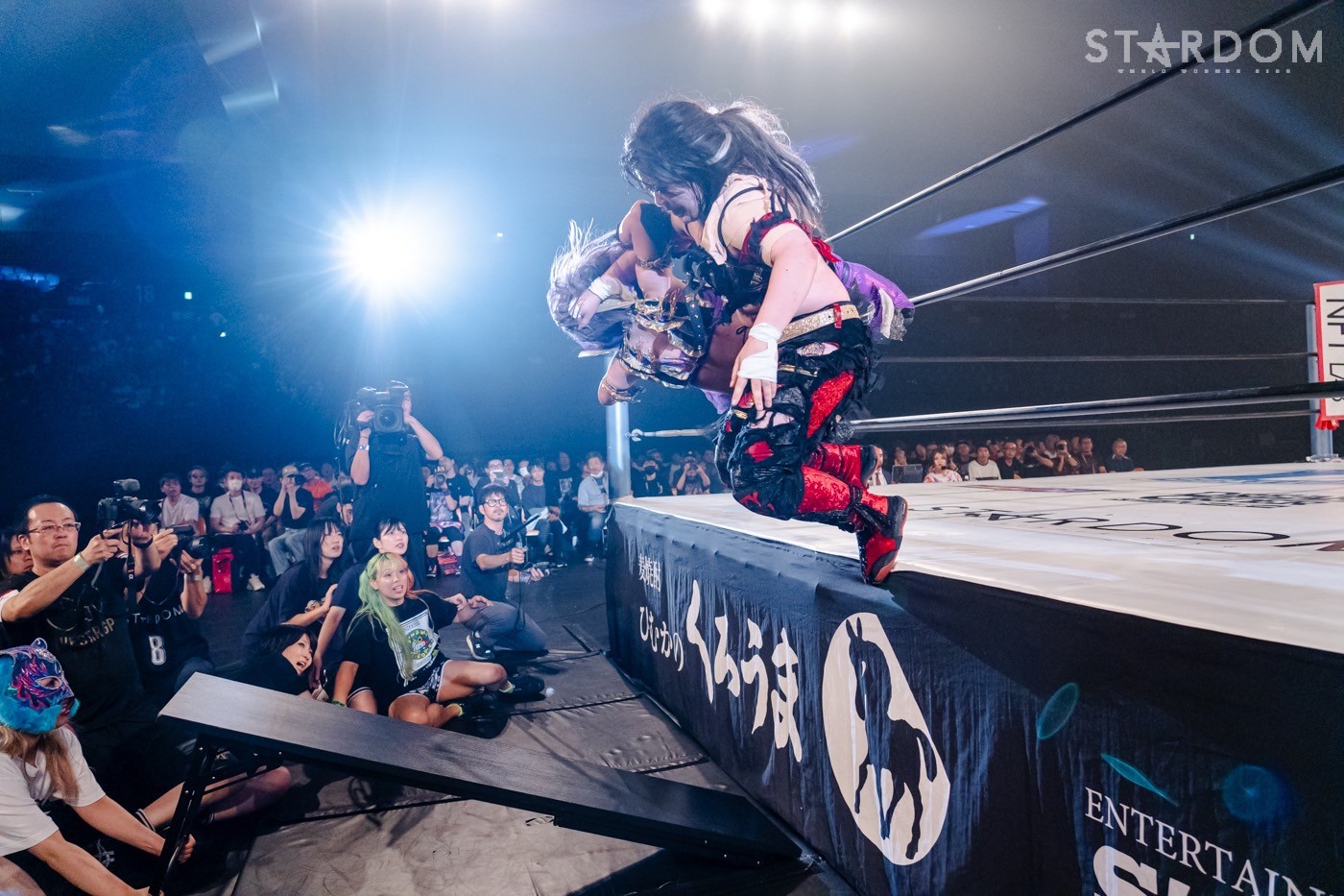 Suzu Suzuki slamming down Tam Nakano from the apron onto a folded table below