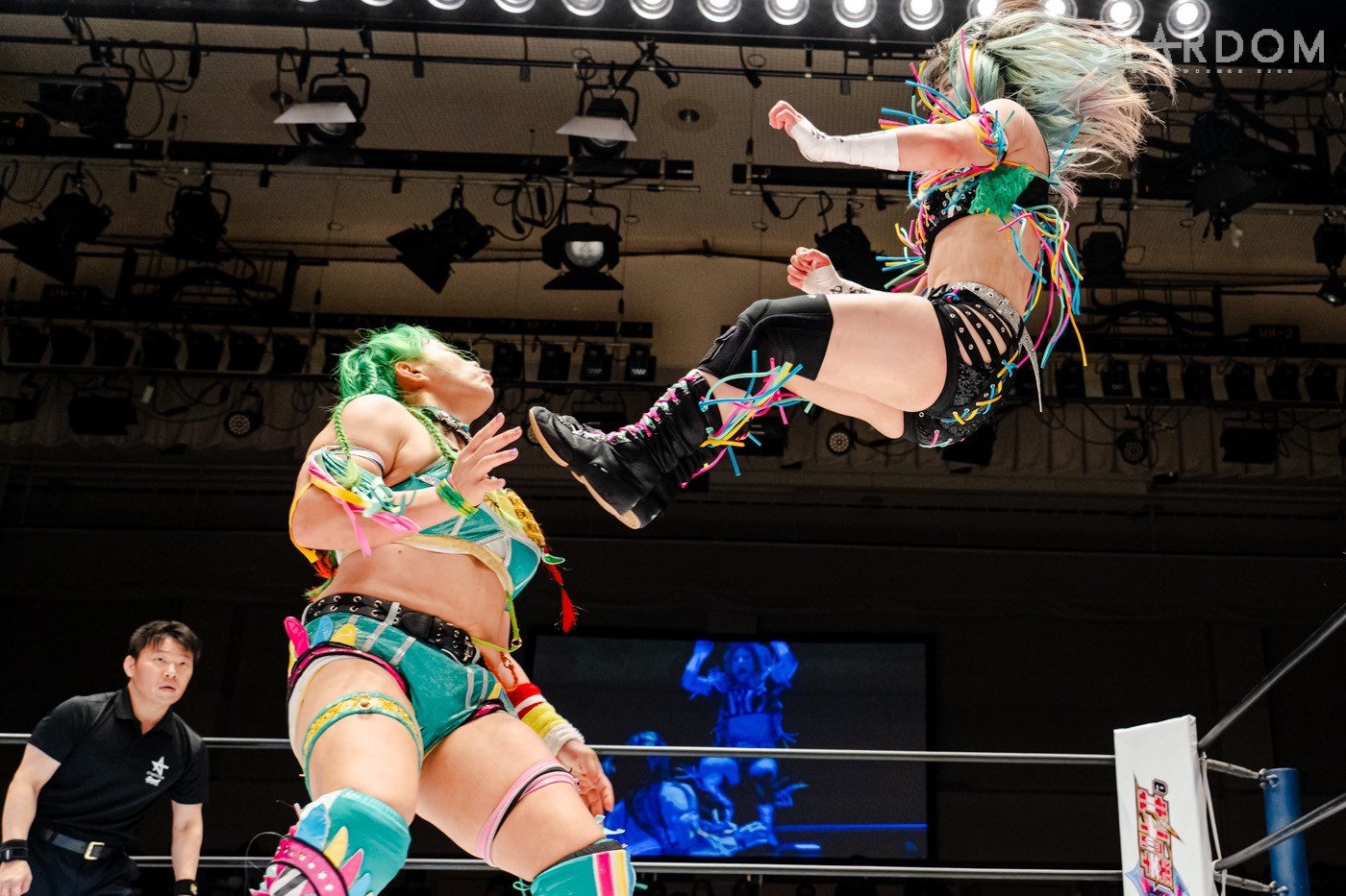 Mei Seira above in the air about to hit Yunamon with a missile kick